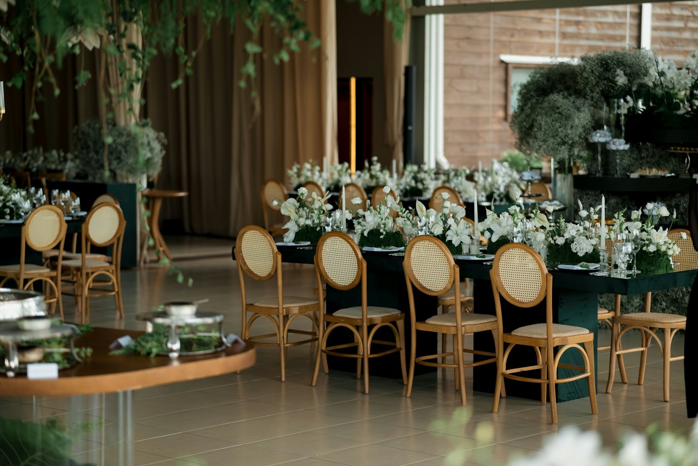 Elegant event space with long tables, floral arrangements, and candles.